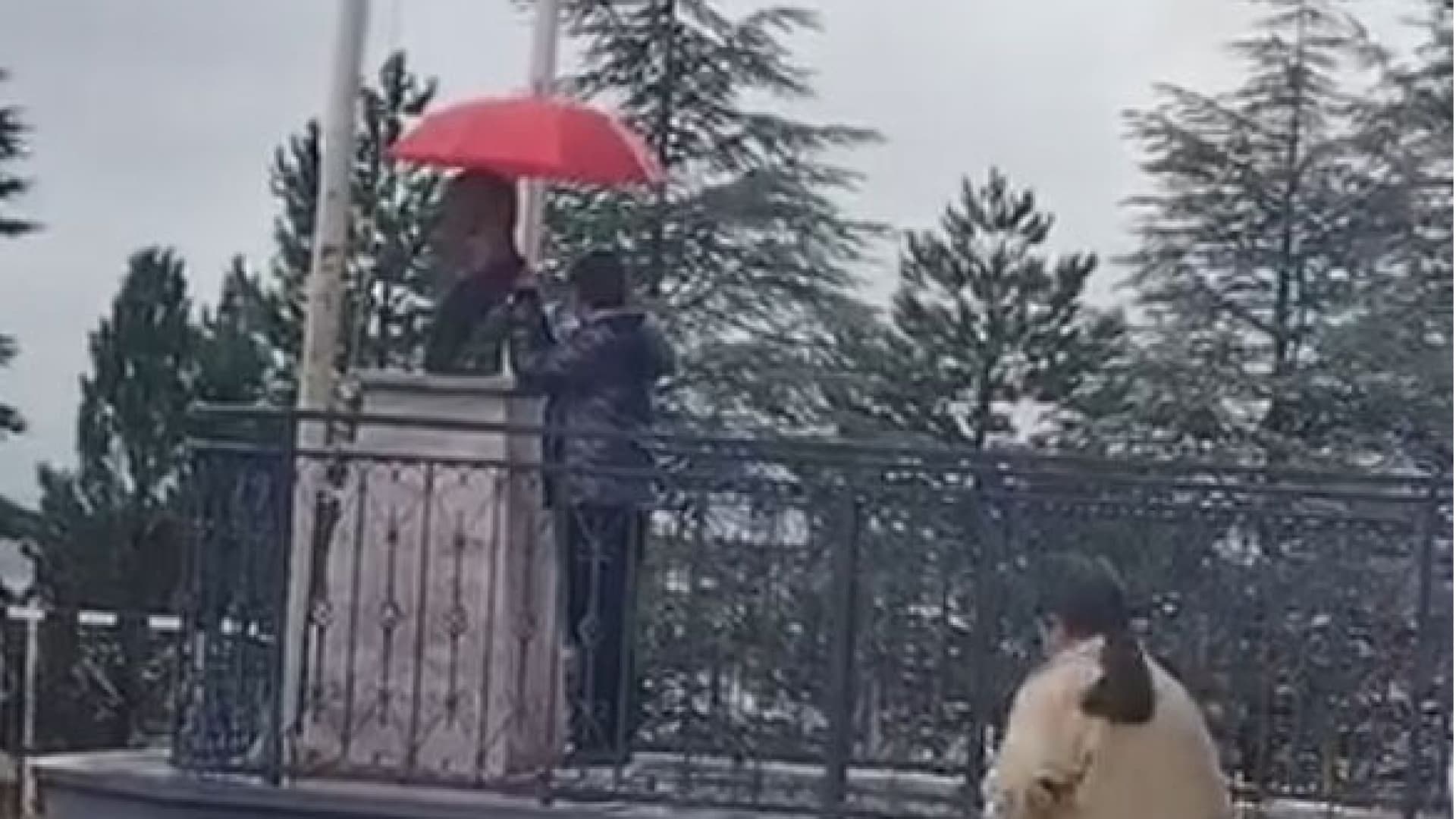 Atatürk büstünü şemsiyeyle korudu